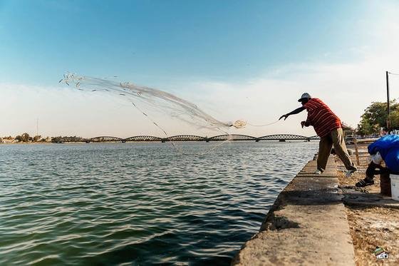 Silhouette d’un homme sur un quai, au bord de l’eau