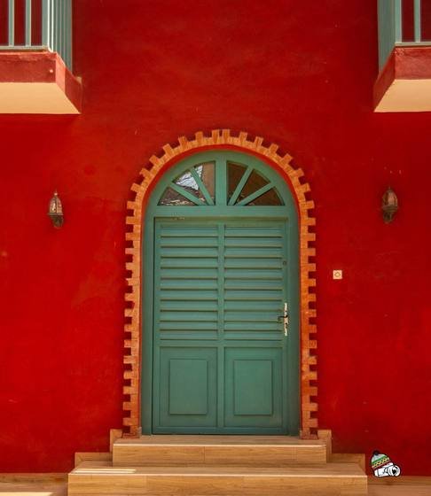 Porte verte dans un mur rouge