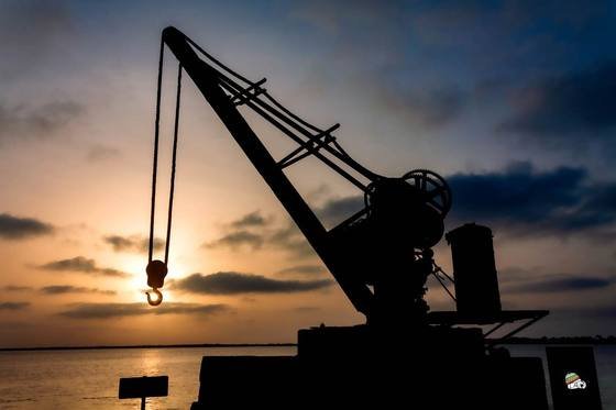Grue portuaire à contre-jour au coucher du soleil