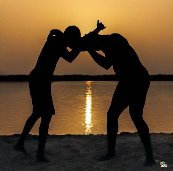 Deux lutteurs en silhouette au coucher du soleil
