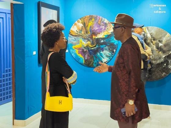 Visiteurs devant une œuvre murale colorée