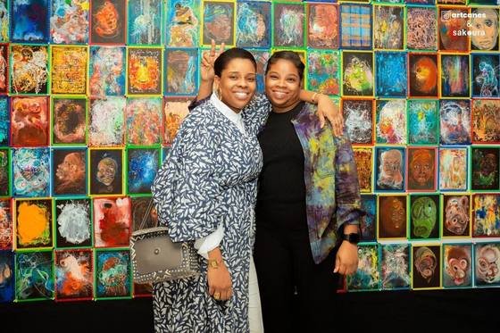 Deux visiteuses devant le mur de tableaux
